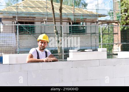 profession construction worker - work on a building site construction of a residential house - quality control Stock Photo