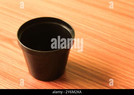 black plastic cup or bowl put on wooden table , coffee cup Stock Photo