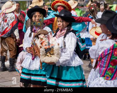 Men and women in traditional Peruvian attire participate in a vibrant festival parade, showcasing rich cultural heritage with colorful costumes and sy Stock Photo