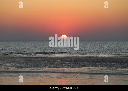 Sunset on the sea beach of Sankt Peter Ording with a beautiful play of colours on the water surfaces, copy space Stock Photo