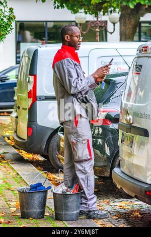Black French African man, service engineer, checking mobile phone - Tours, Indre-et-Loire (37), France. Stock Photo