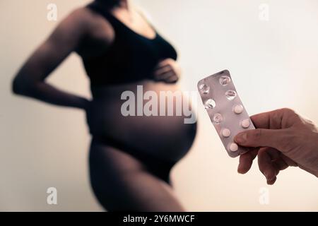 Pregnancy and medicine. Pregnant and pills for vitamins or iodine. Anemia, iron shortage and deficiency. Supplement medication or drug for sick woman. Stock Photo