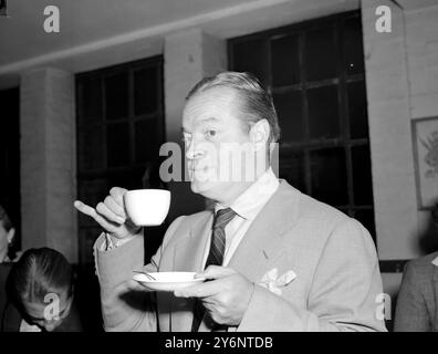 london: Bob Hope drinks tea during visit to Clubland gave a gift of 12,000 for rebuilding of club premises to Rev James Butterworth the founder. 13 September 1952  Hope, Bob (orig. Leslie Townes Hope) US (English-born) actor and comedian; host or co-host of Academy Awards ceremony eighteen times 1939-1977; with Bing Crosby, co-starred in seven 'Road' movies 1940-1962; known for overseas tours entertaining US troops, especially at Christmas, beginning in 1941; co-wrote memoir 'Don't Shoot, It's Only Me' 1990; named honorary US veteran by Congress 1997 (only person to be so designated)  1903-200 Stock Photo