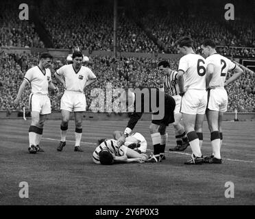 4th May 1957: The FA cup final at Wembley Stadium. Aston Villa (2) versus Manchester United (1). Photo shows: The injured Manchester United goalkeeper, Ray Wood and Aston Villa's Peter McParland (striped shirt) are prostrate after colliding in the goal area in the early stages of the match. Referee, F B Coultas (East Riding) bends over them. Looking on are United players (l-r) Roger Byrne, captain, Jackie Blanchflower, centre-half, who took over in goal, Duncan Edwards and Bill Foulkes. In the centre Stock Photo