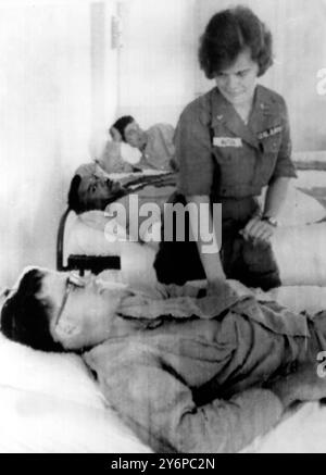 Nurse Sharie Butler of Yankton , South Dakota , takes the pulse of Airman 2nd Class Howard White , of Bowling Green , Ohio , one of the flight line workers wounded in a mammoth explosion at the Bien Hoa airbase early today . The wounded were removed to a Saigon military hospital for treatment . At least 21 people were killed , 37 injured and 22 aircraft destroyed in the wave of explosions . An official spokesman quoted Maj Gen Joseph Moore , Commander of all US Air Force Units in Vietnam , as saying that no sabotage or Viet Cong action was involved . ' It was an accidental explosion of a bomb Stock Photo