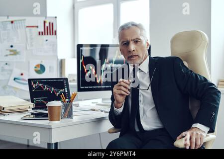 Senior trader in elegant business looking at camera while working at the office Stock Photo