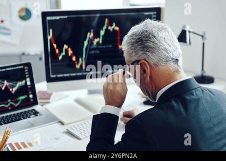 Top rear view of senior trader in elegant business suit using computer while working at the office Stock Photo