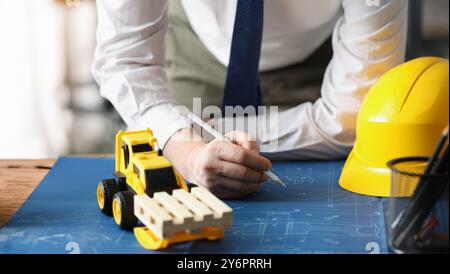 Male worker making corrections in construction planning with pencil Stock Photo