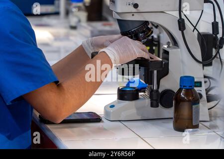 scientist woman on hospital lab working with microscope and smartphone Stock Photo