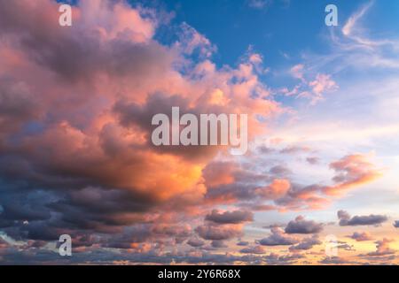 Small clouds in dramatic real sky at sunset texture background overlay. Dramatic blue, orange, and purple clouds. High resolution photograph perfect f Stock Photo