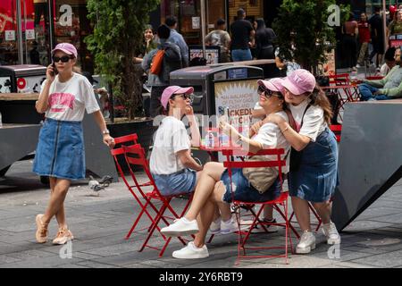 Group of young women in matching outfits visiting Time Square and having fun, 2024, New York City, USA Stock Photo