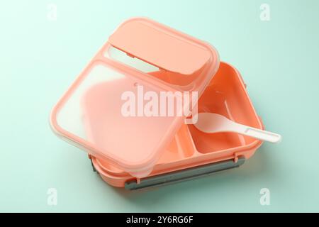Empty lunch box with spoon on light blue background Stock Photo