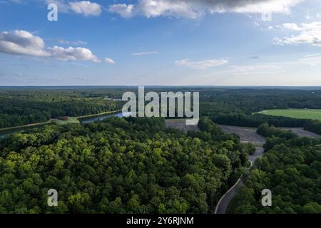 A lush green forest with a river running through it. The sky is clear and blue. Richmond, USA Stock Photo