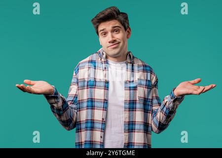 Ignorant mature 30s man, shoulders up - can't help,makes I dont know on blue Stock Photo