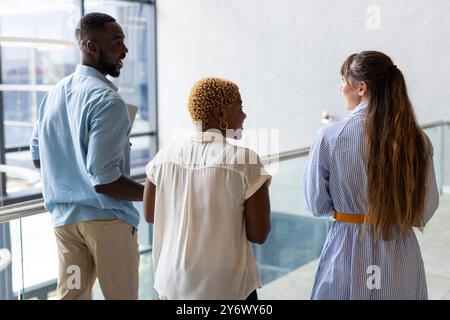 Business colleagues walking and discussing work in modern office building Stock Photo