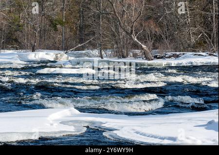 ice covered rocks in fast moving water Stock Photo