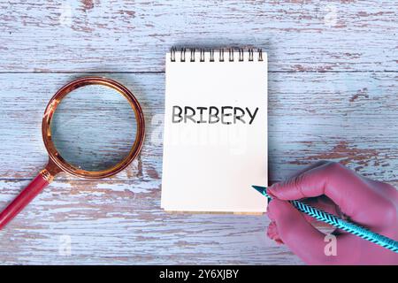 BRIBERY word written there is a handwritten inscription in the notebook Stock Photo