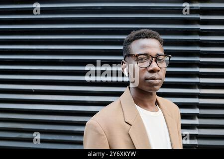 Young Man In Eyeglasses Standing Outdoors Stock Photo