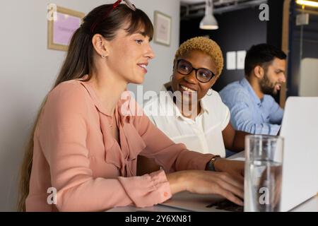 Collaborating on project, diverse colleagues using laptops and discussing ideas in office Stock Photo