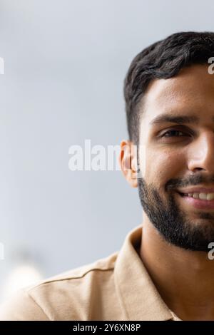 Smiling man with beard wearing beige shirt, looking at camera, close-up portrait, copy space Stock Photo