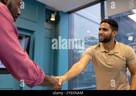 Shaking hands, two men meeting and greeting in modern office setting Stock Photo