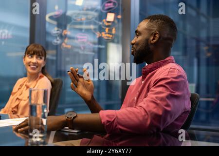 Discussing project ideas, colleagues collaborating in modern office meeting room Stock Photo
