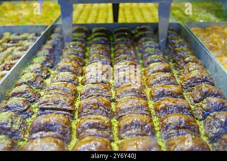 A close-up of a tray of freshly baked chocolate baklava with chopped pistachios. The traditional Turkish dessert in a shop window on Istiklal Street Stock Photo