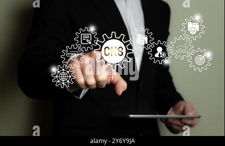 Businessman interacting with a virtual CMS interface, concept of content management system technology. Stock Photo