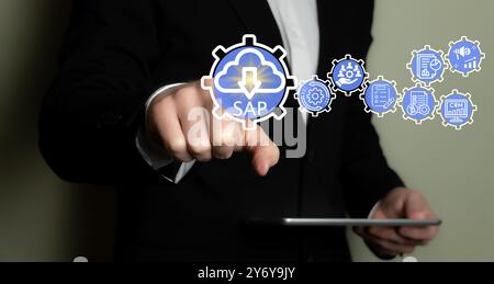 A businessman interacting with a virtual interface featuring SAP and various related icons, showcasing modern business technology. Stock Photo