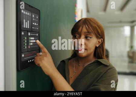 Young Woman Using Interactive Touchscreen in Office Stock Photo