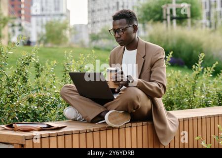 Gen Z Black Guy Working On Laptop During Coffee Break Stock Photo