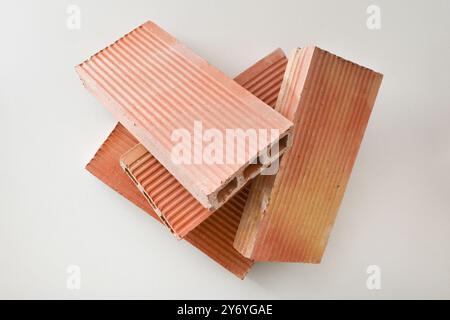 Pile of orange bricks with three holes isolated on white background. Top view. Stock Photo