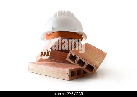 Pile of bricks and white construction helmet on top on white base isolated on white background. Front view. Stock Photo