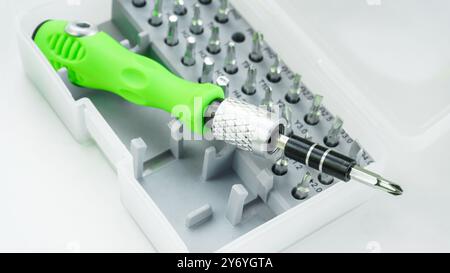Changeable set of magnetic nozzles for a replaceable screwdriver metal steel bits in a plastic box. Working tools isolated on white background. Stock Photo