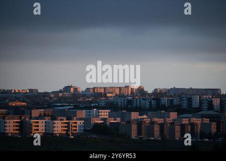 Modern cityscape with buildings in evening light under cloudy sky Stock Photo