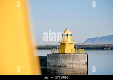 Lighthouse on concrete pier against blue sky Stock Photo