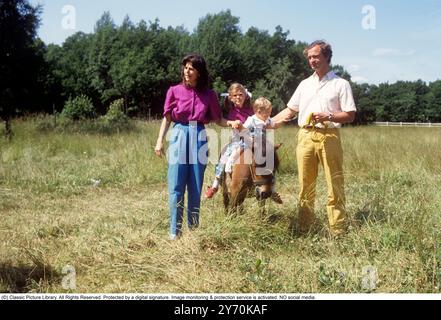 Carl XVI Gustaf, King of Sweden and family 1983. The King Carl XVI Gustaf, Queen Silvia and their children, crown princess Victoria and princess Madeleine on the ground of Solliden castle on Öland. The children are riding a small horse. Stock Photo