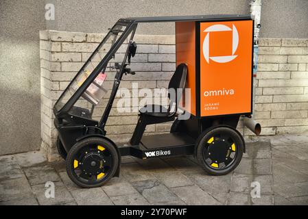 Pedal powered Omniva postal mail delivery EV vehicle Vok Bikes with storage for parcels, delivery in Old Town on cobblestone streets Tallinn, Estonia. Stock Photo