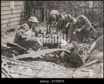 GERMAN PLANE SHOT DOWN ON OUTSKIRTS OF LONDON - DISGUISED PLANE USED IN LONDON RAIDSA German bomber returning after taking part in the early morning raids on London was shot down on the outskirts of London. The plane crashed on a row of houses setting fire to one of them and broke into pieces. Attempts had been made to disguise the plane which had the swastika blacked over. The yellow nose indicating that the plane belonged to Goering's picked squadron had also been painted over. PHOTO SHOWS:- The nose of the German machine being examined by Air force men. undated 1940 Stock Photo