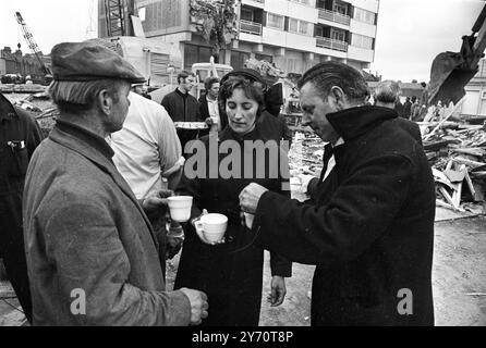 Members of the Salvation Army hand out welcome cups of tea to rescue workers at the scene of today's partial collapse of a recently completed 23 storey block of flats at Customs House , East London . The collapse occurred at 6 o'clock this morning . One eye witness said there appeared to have been an explosion . The latest casualty figures are three dead , nine injured and seven , including three married couples , unaccounted for . Rescue operations were later because of the dangerous situation in which the men were working in . - - The tower block is also known as Ronan Point , named after De Stock Photo