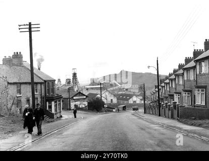 First large scale dismissal of miners in the present crisis .   Ferryhill , Couty Durham :  A view down the road in the village of Ferrihill , with  the Dean and Chapter Colliery in the background .  The mine works 1,500 men , but the mountain of spoil in the background , shows clearly enough how much good coal has already been worked out .  26 April 1958 Stock Photo