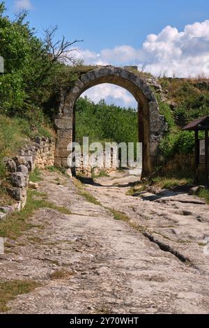 An ancient stone archway leading into a weathered, empty room with ...