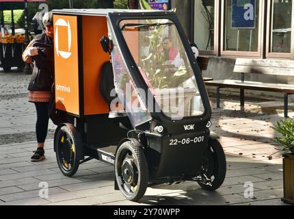 Pedal powered Omniva postal mail delivery EV vehicle Vok Bikes with storage for parcels, delivery in Old Town on cobblestone streets Tallinn, Estonia. Stock Photo