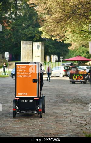 Pedal powered Omniva postal mail delivery EV vehicle Vok Bikes with storage for parcels, delivery in Old Town on cobblestone streets Tallinn, Estonia. Stock Photo