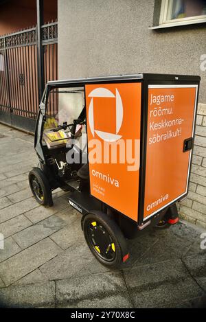 Pedal powered Omniva postal mail delivery EV vehicle Vok Bikes with storage for parcels, delivery in Old Town on cobblestone streets Tallinn, Estonia. Stock Photo