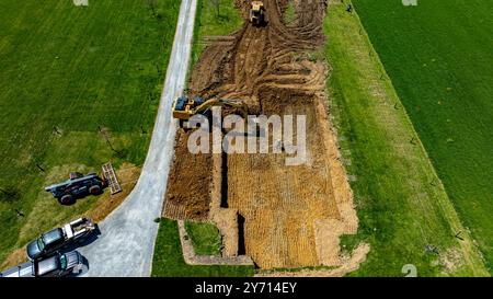 An excavator is digging into the ground to prepare a foundation for ...