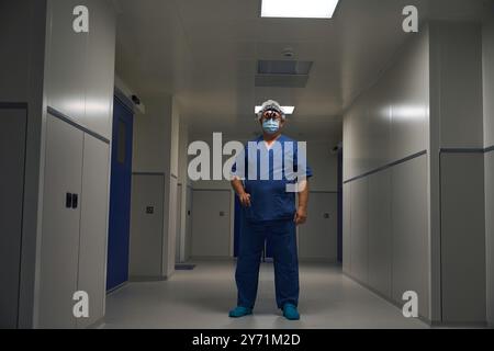 Doctor in scrubs standing in hospital hallway Stock Photo