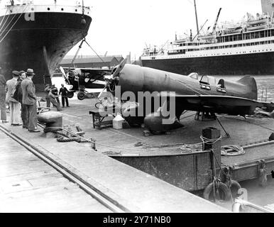 Mr Jack Wright and Mr John Polando Warner arrive in Southampton to compete in the London to Melbourne Air Race . Their Lambert Monocoupe 145 ' Baby Ruth ' is furthest away . Also arriving aboard the liner Olympic was the Granville R-6H ' QED ' entered by Miss Jacqueline Cochran , the American airwoman . 12 October 1934 Stock Photo