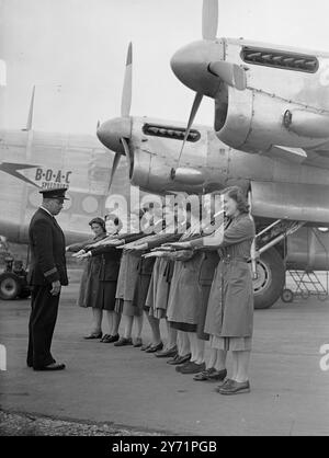 AIR STEWARDESSES IN THE MAKING   At the B.O.A.C. staff Training School at Hurn Airport , girls are undergoing instruction in the duties of a B.O.A.C. Stewardess . In a 'mock up'  of an airliner's cabin , the girls are taught the best way of preserving food with the aid of refrigerators , as well as how to serbe food at the table when the aircraft is in flight , and other duties of a stewardess .     PICTURE SHOWS:-  Morning inspection-  The Chief Instructor gives the girls hands an inspection t insure the standard of hygiene is maintained . Right to left are:   C. Robertson of Dunfermline , Stock Photo