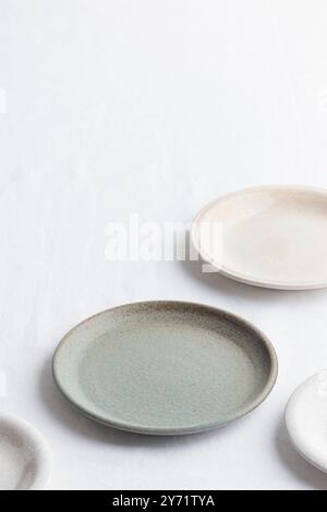 Empty rustic vintage plates dinnerware on a white tablecloth with copy space as a background for meal food dishes, food mock-up Stock Photo